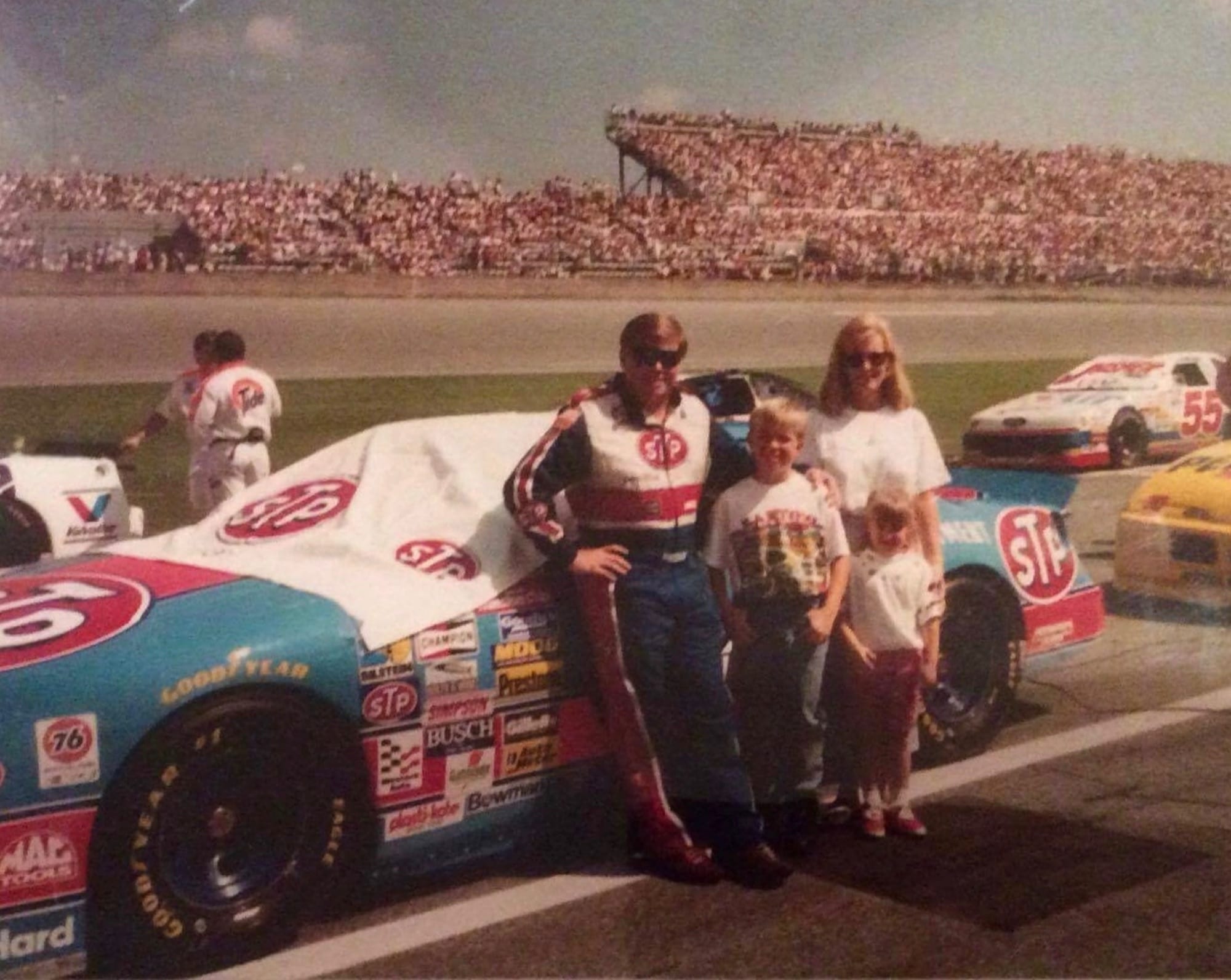 Rick Wilson in his driving suit on pit road with his wife Teresa and their three children